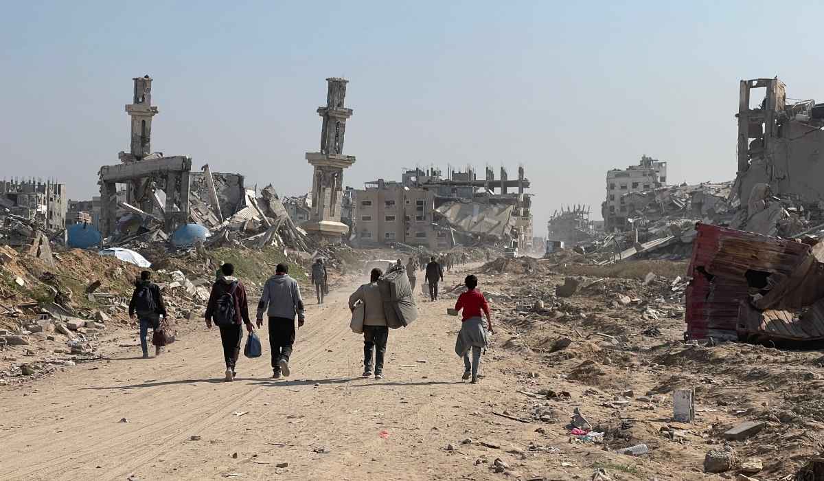 Dei Palestinesi lasciano Gaza tra le macerie.